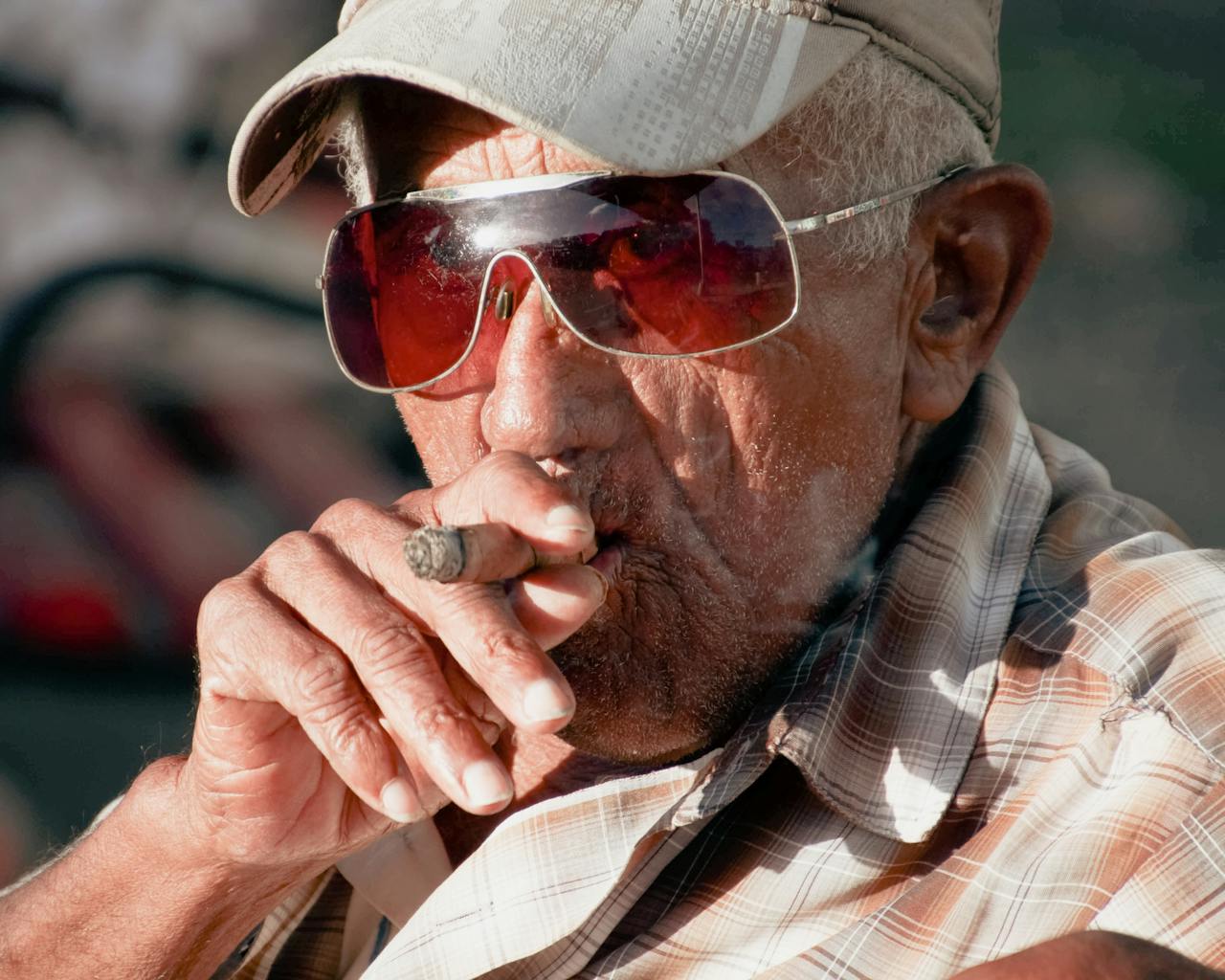 Close-up of a senior man smoking a cigar, showcasing leisure and lifestyle.